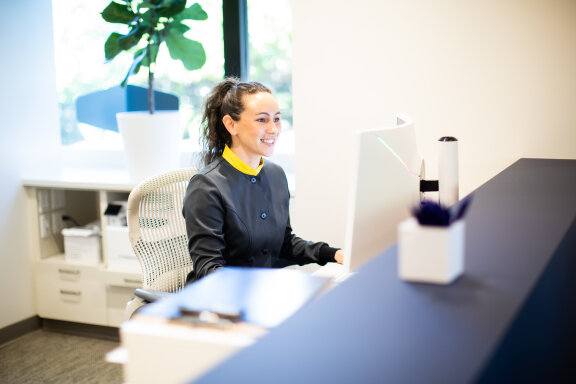 Employee Smiling at Front Desk